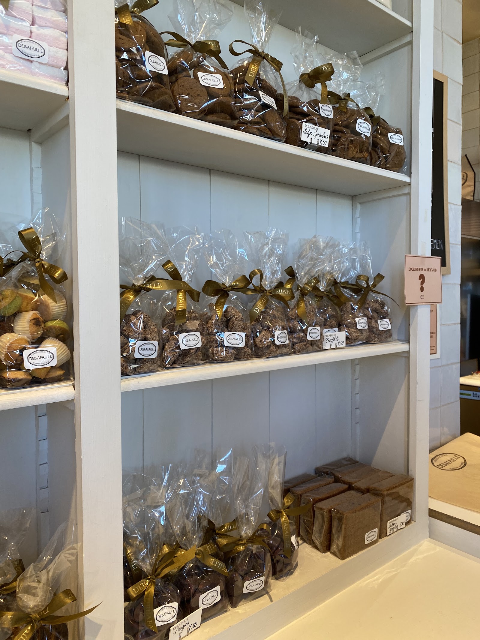 Schappen met ingepakte huisgemaakte chocolade en koekjes met gouden lintjes